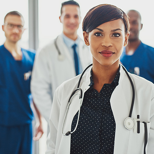 a doctor standing with their team in the background